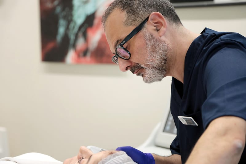 Il Prof. Coricciati chino su un paziente durante una visita